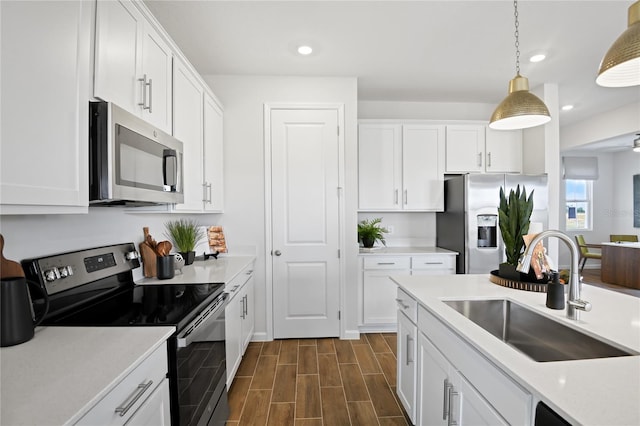kitchen featuring recessed lighting, a sink, white cabinetry, and appliances with stainless steel finishes