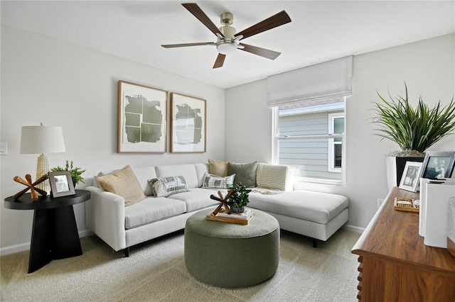 carpeted living area featuring baseboards and ceiling fan