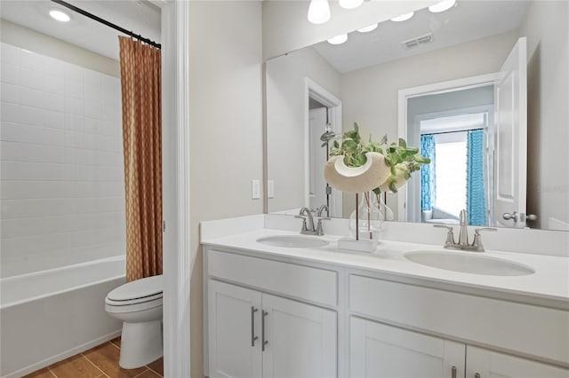 full bath with double vanity, toilet, visible vents, and a sink