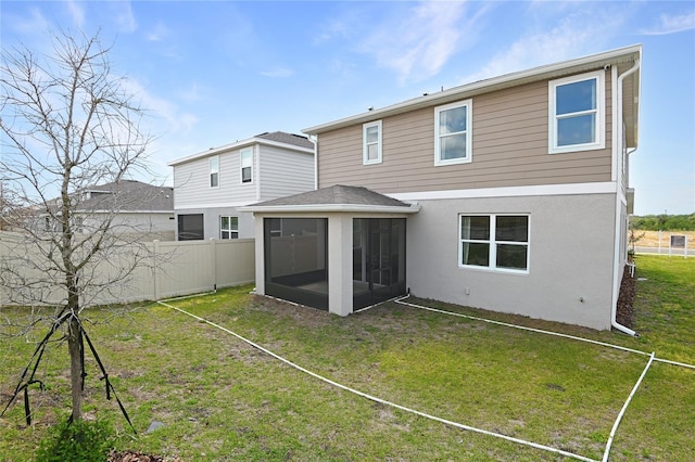back of house with a sunroom, a yard, fence, and stucco siding