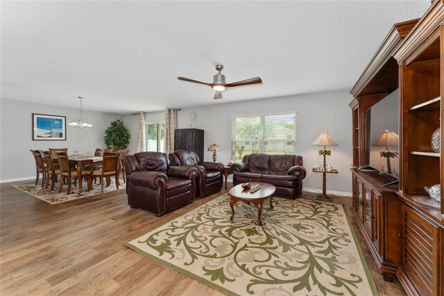 1532 Angler Ave, Kissimmee, FL 34746 - living room with ceiling fan with notable chandelier, baseboards, a healthy amount of sunlight, and wood finished floors
