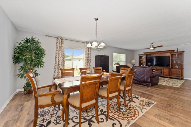 1532 Angler Ave, Kissimmee, FL 34746 - dining room with light wood-style floors, baseboards, ceiling fan with notable chandelier, and a healthy amount of sunlight