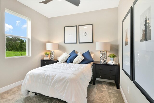 carpeted bedroom with a ceiling fan and baseboards