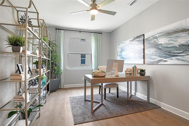 office with baseboards, ceiling fan, visible vents, and wood finished floors