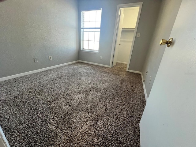 4301 Lizshire Ln Unit 306, Orlando, FL 32822 - unfurnished bedroom featuring a walk in closet, baseboards, a closet, and carpet