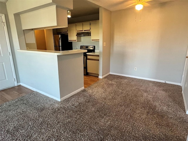 4301 Lizshire Ln Unit 306, Orlando, FL 32822 - kitchen with freestanding refrigerator, stainless steel range with electric stovetop, under cabinet range hood, ceiling fan, and carpet flooring