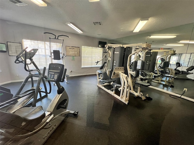 4301 Lizshire Ln Unit 306, Orlando, FL 32822 - workout area featuring plenty of natural light, a textured ceiling, and baseboards