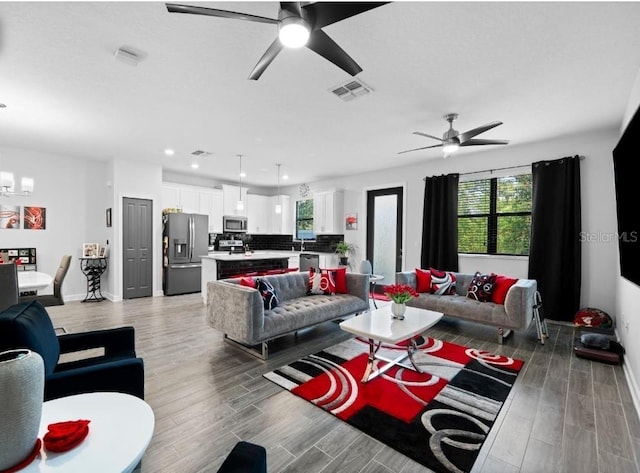 1231 Sandwedge St, Davenport, FL 33896 - living room with visible vents, plenty of natural light, ceiling fan with notable chandelier, and light wood finished floors