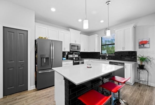 1231 Sandwedge St, Davenport, FL 33896 - kitchen featuring backsplash, stainless steel appliances, light wood-type flooring, and white cabinetry