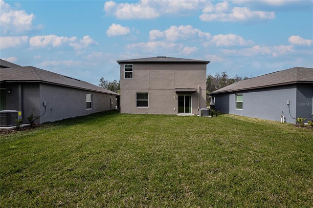 2189 Teneroc Trl, Lakeland, FL 33801 - back of house with central air condition unit, a lawn, and stucco siding