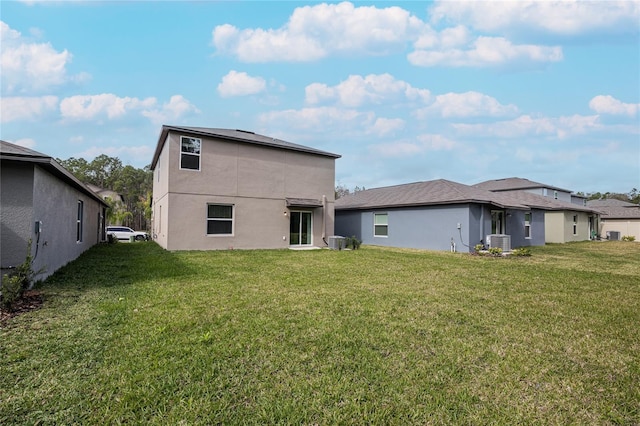 2189 Teneroc Trl, Lakeland, FL 33801 - rear view of house with a yard, cooling unit, and stucco siding