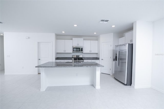 2189 Teneroc Trl, Lakeland, FL 33801 - kitchen with white cabinets, dark stone countertops, stainless steel appliances, recessed lighting, and visible vents