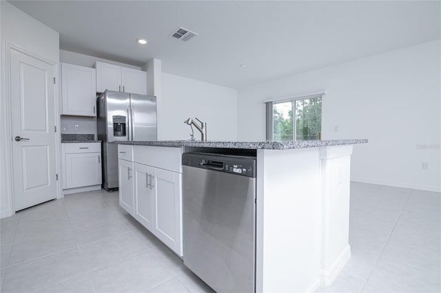 2189 Teneroc Trl, Lakeland, FL 33801 - kitchen featuring appliances with stainless steel finishes, a center island with sink, white cabinetry, and visible vents