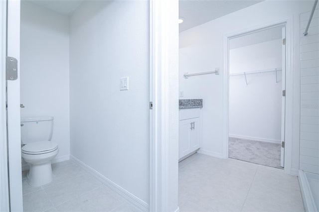 2189 Teneroc Trl, Lakeland, FL 33801 - bathroom with a walk in closet, tile patterned flooring, vanity, baseboards, and toilet
