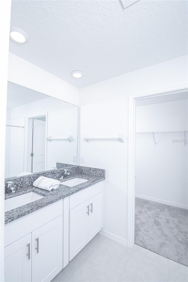 2189 Teneroc Trl, Lakeland, FL 33801 - bathroom with double vanity, a walk in closet, a sink, and tile patterned floors