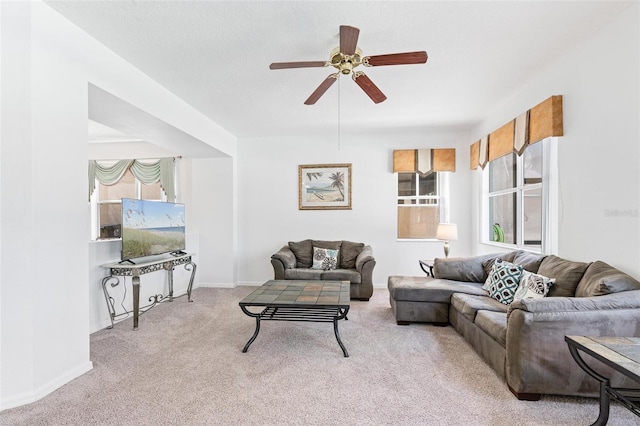 carpeted living room featuring baseboards, plenty of natural light, and ceiling fan