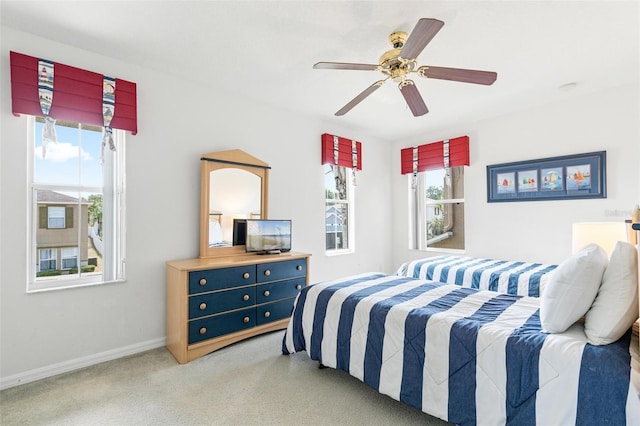 carpeted bedroom featuring baseboards and ceiling fan