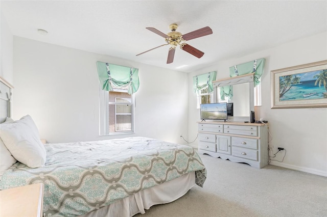carpeted bedroom with baseboards and a ceiling fan
