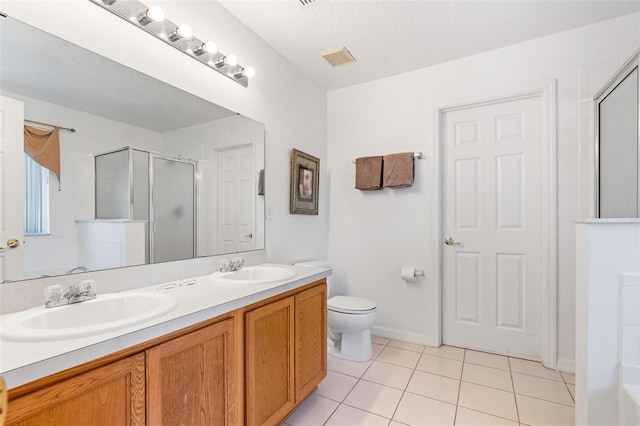full bathroom with a sink, tile patterned flooring, a stall shower, and double vanity