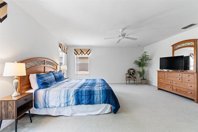 bedroom with carpet floors, a ceiling fan, a textured ceiling, and visible vents