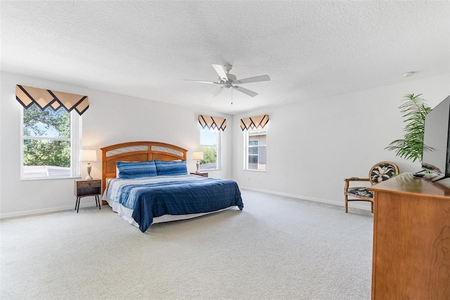 bedroom featuring baseboards, multiple windows, a textured ceiling, and light colored carpet