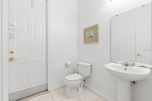 half bathroom featuring baseboards, tile patterned floors, and toilet