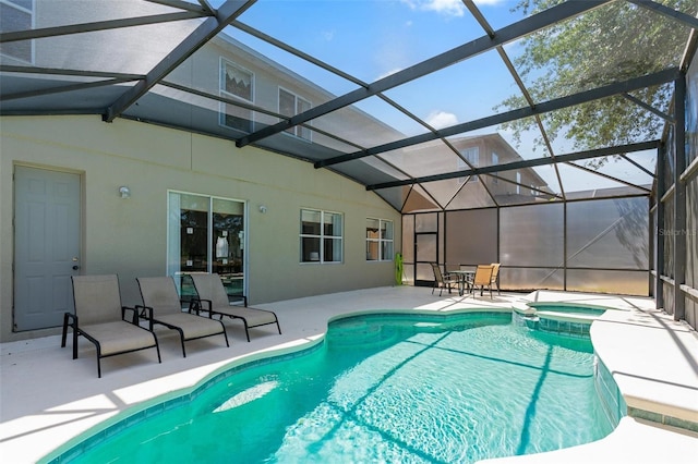 view of pool featuring a lanai, a pool with connected hot tub, and a patio area