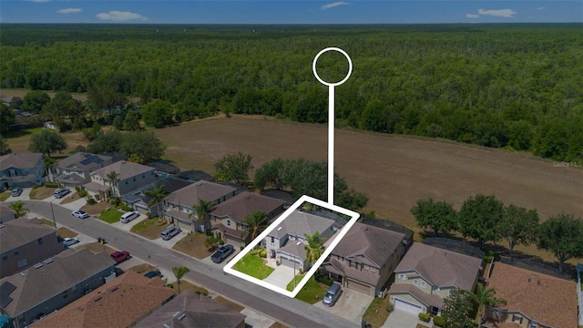 drone / aerial view featuring a residential view and a view of trees