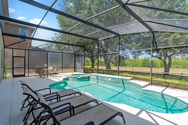 view of pool with a pool with connected hot tub, a lanai, and a patio area