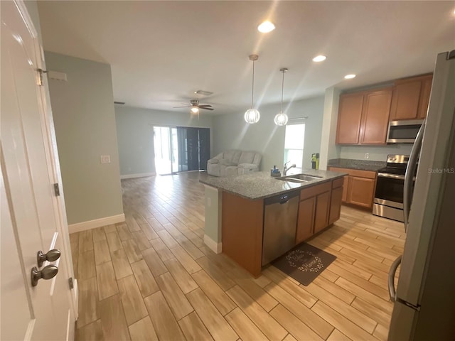 kitchen featuring ceiling fan, light wood-style flooring, appliances with stainless steel finishes, and a sink