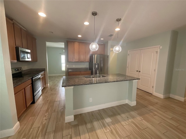 kitchen featuring a sink, appliances with stainless steel finishes, recessed lighting, baseboards, and light wood-style floors