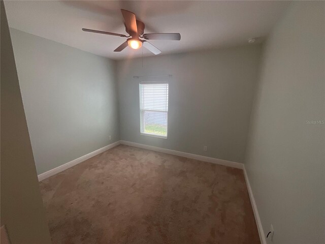spare room with light carpet, baseboards, and ceiling fan