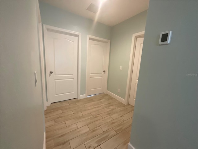 hall featuring wood finish floors and baseboards