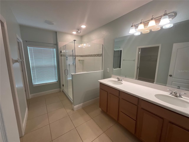 bathroom featuring a stall shower, tile patterned floors, double vanity, and a sink