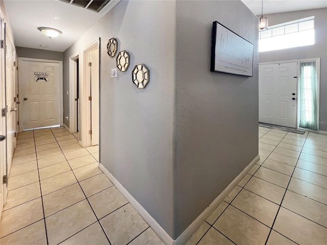 8439 Adele Rd, Lakeland, FL 33810 - hall with light tile patterned floors, visible vents, and baseboards