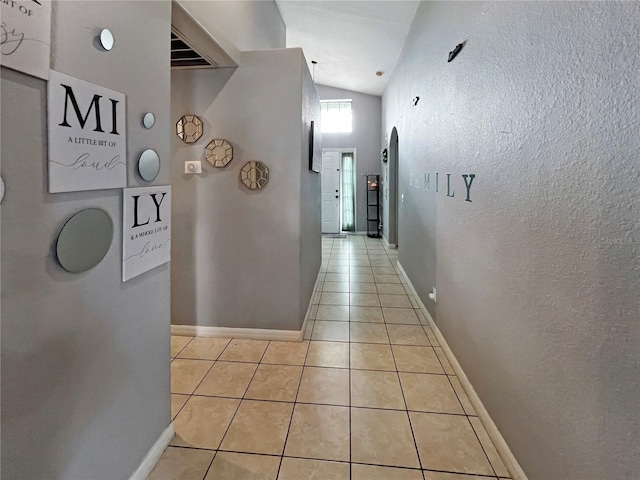 8439 Adele Rd, Lakeland, FL 33810 - hallway with vaulted ceiling, baseboards, and light tile patterned floors