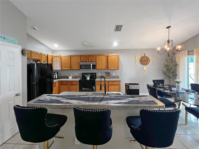 8439 Adele Rd, Lakeland, FL 33810 - kitchen featuring black appliances, visible vents, vaulted ceiling, light tile patterned floors, and a notable chandelier