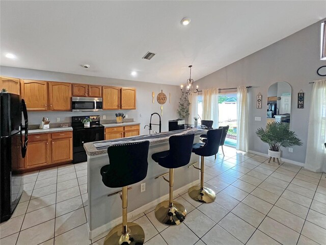 8439 Adele Rd, Lakeland, FL 33810 - kitchen with light tile patterned floors, black appliances, an inviting chandelier, and visible vents