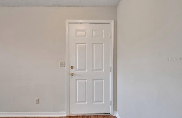 unfurnished room featuring baseboards and wood finished floors
