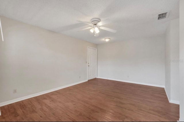 unfurnished room featuring visible vents, baseboards, ceiling fan, and wood finished floors