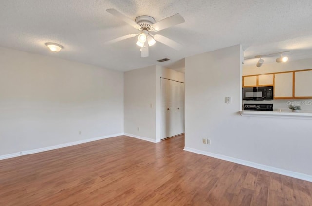 unfurnished living room featuring baseboards, a ceiling fan, light wood finished floors, and a textured ceiling