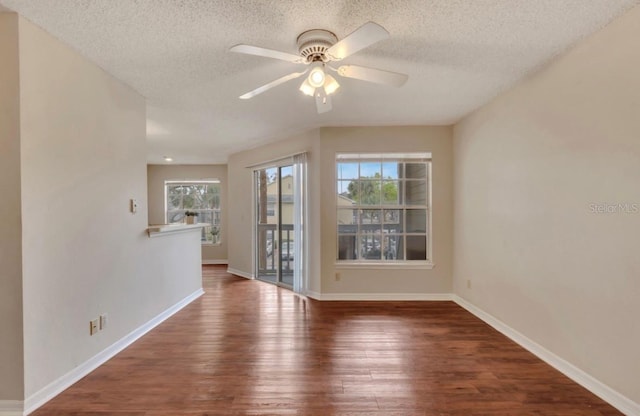 unfurnished room with baseboards, a textured ceiling, ceiling fan, and wood finished floors