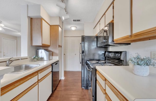 kitchen featuring visible vents, black range with electric stovetop, dishwasher, a sink, and light countertops
