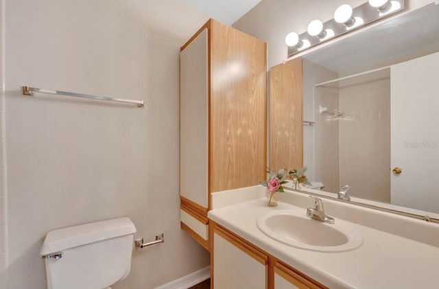 bathroom with toilet, walk in shower, and vanity