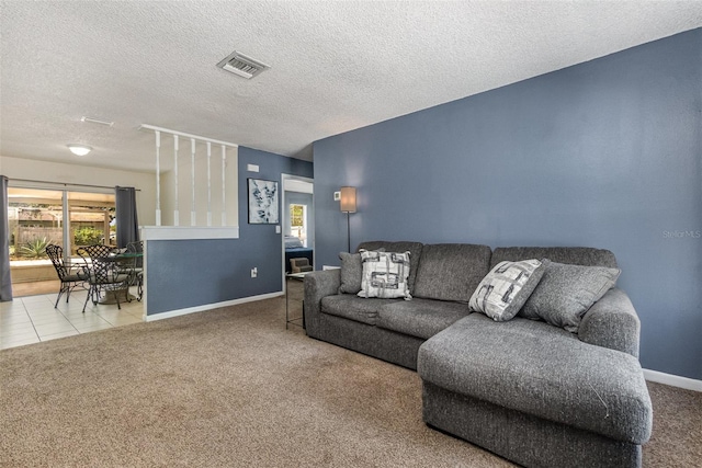 carpeted living room featuring baseboards and a textured ceiling