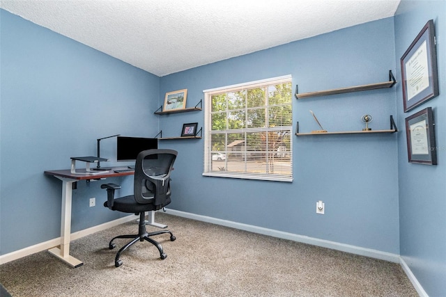 carpeted office space with a textured ceiling and baseboards