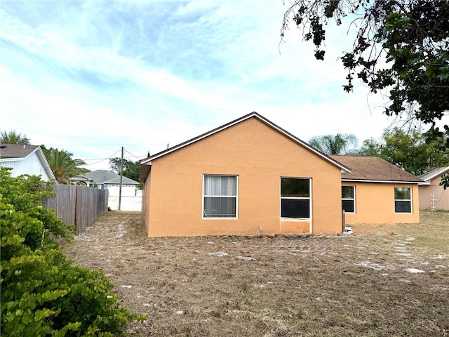 view of property exterior featuring stucco siding and fence