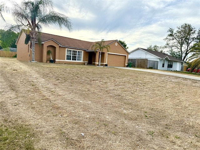 single story home with concrete driveway, a garage, fence, and stucco siding