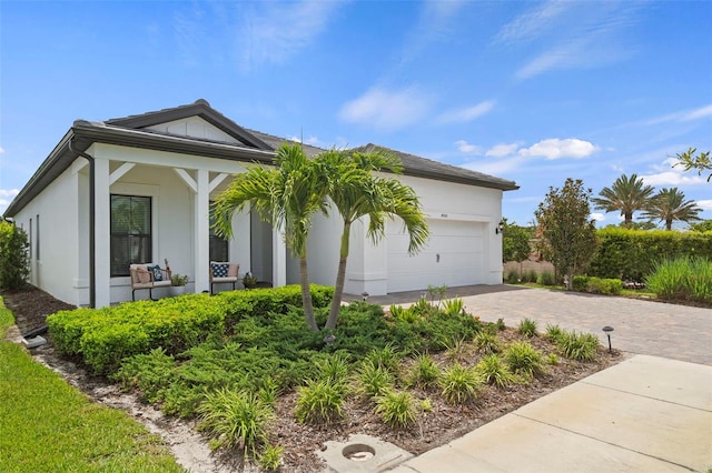 view of home's exterior with a garage, stucco siding, and decorative driveway