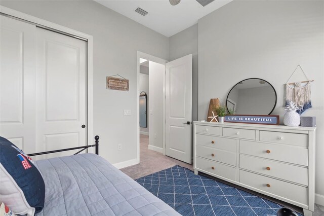 bedroom with baseboards, a closet, dark colored carpet, and visible vents